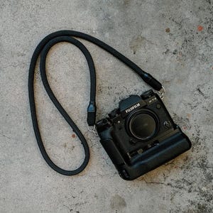富士フイルム、キヤノン、ライカ、ソニー、フィルムカメラ用の黒のカメラネックストラップ。