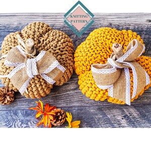 Könnte beinhalten: Zwei gestrickte Kürbisse, einer braun und einer gelb, mit Juteschleifen und weißen Spitzenakzenten. Die Kürbisse liegen auf einer Holzoberfläche. "Strickmuster" steht auf einer rosa-türkisen Raute.