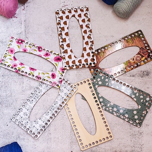 Peut inclure: Six aiguilles à tricoter en bois avec différents motifs. Les motifs comprennent des motifs floraux, des tasses de café et une scène d'hiver. Les aiguilles sont toutes rectangulaires et ont un trou au centre.