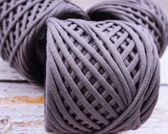 May include: Three balls of gray yarn, made of a thick, woven fabric. The yarn is arranged in a triangular shape.