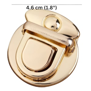 May include: Gold-toned metal clasp with a round base and a hinged latch. The clasp measures 4.6 cm (1.8 inches) in diameter.