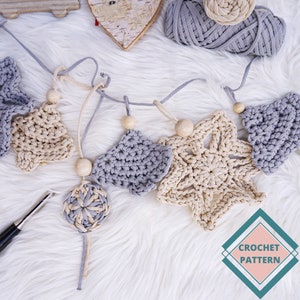 May include: A crocheted garland featuring a beige and grey colour scheme. The garland includes a variety of shapes, such as stars, trees, and circles. The garland is strung with wooden beads and is ideal for adding a touch of handmade charm to your home decor.