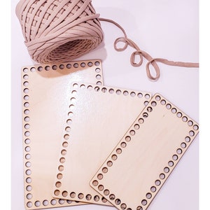 May include: Three wooden loom boards of different sizes, with a beige yarn ball and a length of yarn on a white background.