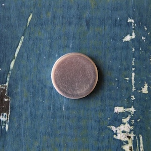 May include: A silver-colored round coin with a smooth surface.