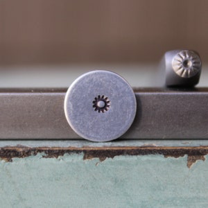 May include: Two metal stamps with a star design. The stamp on the left is a round head stamp, while the stamp on the right is a rectangular head stamp.