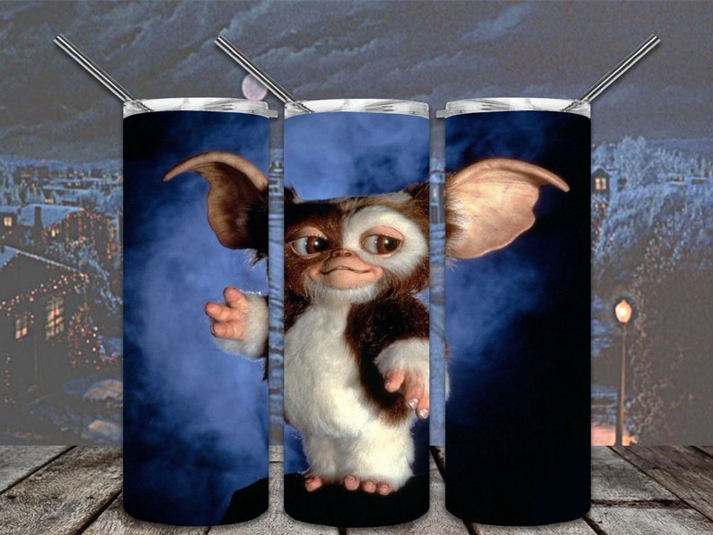 May include: Three stainless steel tumblers featuring a blue and white image of a furry creature with large ears. The creature is from the film Gremlins.