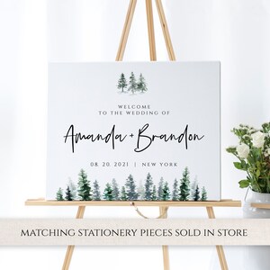 May include: Welcome sign with watercolor forest illustration. The sign reads "Welcome to the wedding of Amanda + Brandon 08.20.2021 | New York"