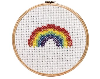 May include: A rainbow cross-stitch design in a wooden embroidery hoop. The rainbow is made of red, orange, yellow, green, blue, indigo, and violet thread.
