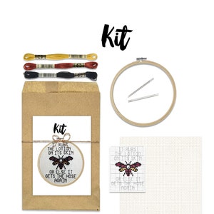 May include: Cross stitch kit featuring a butterfly with the text "It rubs the lotion on its skin or else it gets the hose again". The kit includes embroidery floss, a needle, and a hoop.