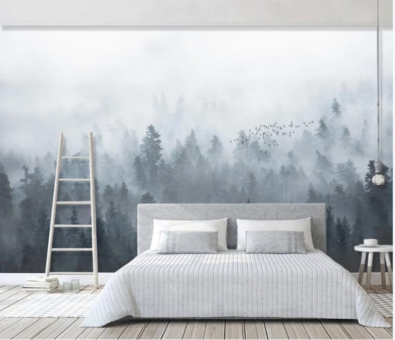Puede incluir: Una cama blanca con una cabecera gris y un edred&oacute;n blanco se encuentra frente a un mural de pared que representa un bosque brumoso con una bandada de p&aacute;jaros volando por encima.