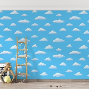 May include: A blue wall decorated with a cloud pattern, a wooden ladder, and a framed alphabet print. A teddy bear and a yellow plush toy sit on a hexagonal shelf. Fairy lights are wrapped around the ladder.