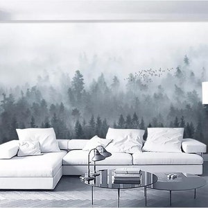 Puede incluir: Un sof&aacute; blanco seccional con almohadas se encuentra frente a un mural de pared que representa un bosque brumoso con una bandada de p&aacute;jaros volando por encima.