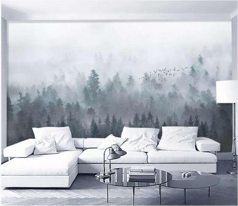 Puede incluir: Un sof&aacute; blanco seccional con almohadas se encuentra frente a un mural de pared que representa un bosque brumoso con una bandada de p&aacute;jaros volando por encima.