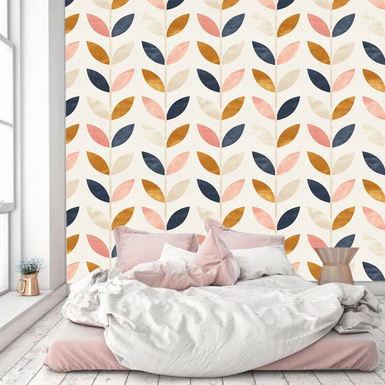 May include: A bedroom with a white wall featuring a repeating pattern of stylized leaves in shades of pink, blue, gold, and cream. The leaves are arranged in a vertical pattern, creating a modern and geometric look.