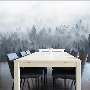 Puede incluir: Una mesa de comedor blanca con seis sillas negras frente a un fondo de bosque brumoso. El bosque est&aacute; representado en tonos de gris y blanco, con una bandada de p&aacute;jaros volando por encima.