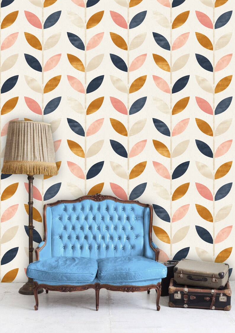 May include: A blue tufted sofa sits in front of a wall with a repeating pattern of stylized leaves in shades of pink, beige, navy blue, and gold.