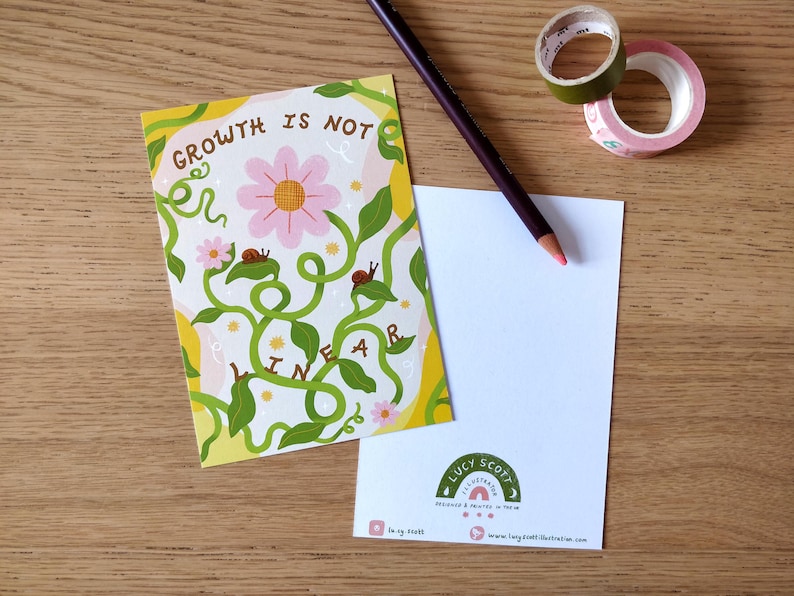 May include: A postcard with the text "GROWTH IS NOT LINEAR" and a floral design, alongside a blank card, a pencil, and decorative tape rolls. The postcard features a pink flower and green vines.