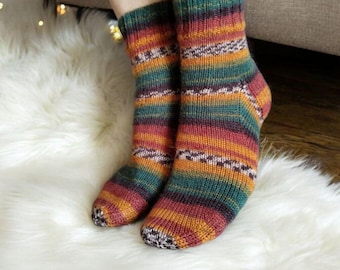 May include: A pair of colorful striped socks in shades of green, orange, red, and brown. The socks are made of a soft, knitted fabric and have a comfortable fit.