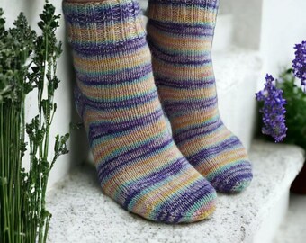 May include: A pair of striped socks in shades of purple, pink, yellow, and blue. The socks are made of a soft, knitted fabric and have a comfortable fit.