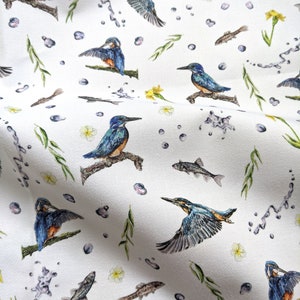 May include: White fabric with a repeating pattern of blue kingfishers, green reeds, and brown fish. The background is white with small blue dots.