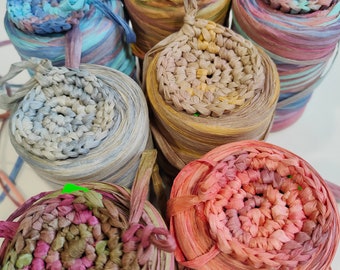 May include: Six spools of colorful paper yarn, each with a crocheted circle on top. The yarn is in shades of blue, brown, pink, and green.