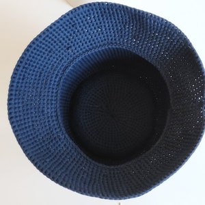 May include: A dark blue crocheted basket with a round shape. The basket is made of thick yarn and has a smooth, even texture.