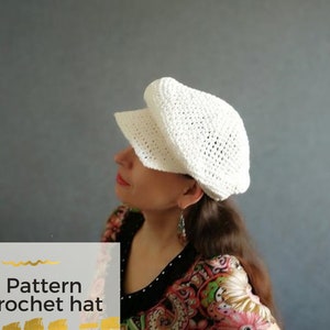 May include: A white crochet hat with a pattern. The hat has a wide brim and is made with a delicate stitch.