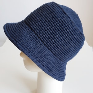 May include: A navy blue crocheted bucket hat with a wide brim.