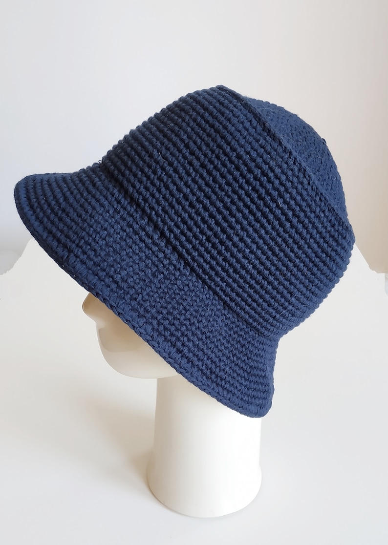 May include: A navy blue crocheted bucket hat with a wide brim.