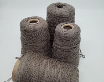 May include: Four spools of gray yarn, wound tightly on cardboard spools.
