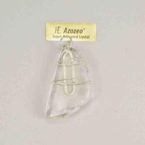 Può includere: Un ciondolo di cristallo trasparente di forma irregolare, avvolto in filo color argento. Il ciondolo è appeso a un anello color argento. Un'etichetta color oro sopra il ciondolo recita "Azozeo Super-activated Crystal."