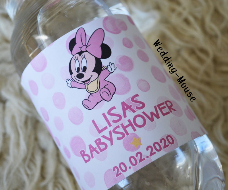以下が含まれることがあります： ピンクと白のラベルが付いた透明なウォーターボトル。ラベルには、ベビーミニーマウスのデザインと「LISAS BABYSHOWER」の文字、日付「20.02.2020」が記載されています。ベビーシャワー向けにデザインされた、シンプルでクリーンなデザインのボトルです。