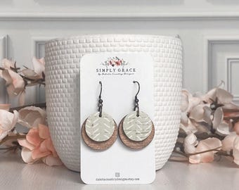 Puede incluir: Un par de pendientes de madera con un patrón geométrico blanco y verde. Los pendientes están en una tarjeta blanca con el texto "SIMPLY GRACE by Dakota Country Designs" y la dirección del sitio web "dakotacountrydesigns.etsy.com".