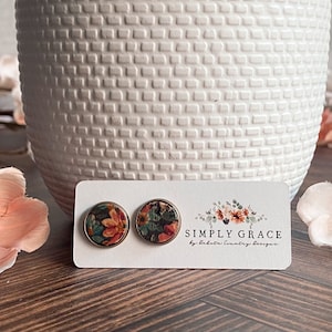 Peut inclure: Une paire de boucles d'oreilles clous à imprimé floral avec un dos argenté. Les boucles d'oreilles sont sur une carte blanche avec le texte "SIMPLY GRACE by Southern Country Boutique".