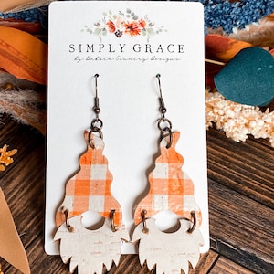 Könnte beinhalten: Ein Paar orange-weiße Gingham-Zwergenohrringe mit weißem Bart. Die Ohrringe befinden sich auf einer weißen Karte mit dem Text "SIMPLY GRACE by Dakota Country Designs".