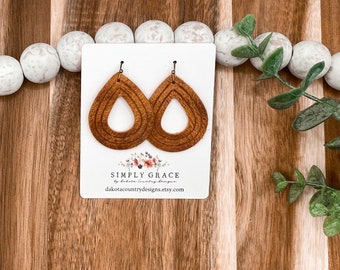 Peut inclure: Une paire de boucles d'oreilles en bois brun en forme de larme avec un design en couches. Les boucles d'oreilles sont sur une carte blanche avec le texte "SIMPLY GRACE by Dakota Country Designs dakotacountrydesigns.etsy.com"