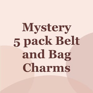 May include: Image features the text "Mystery 5 pack Belt and Bag Charms" in a dark brown font. The text is centered on a light pink background with abstract, lighter pink shapes.