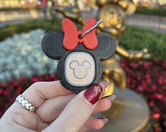Könnte beinhalten: Ein schwarz-roter 3D-gedruckter Minnie Mouse-Schlüsselanhänger mit einem weißen Mickey Mouse-Kopf auf der Vorderseite. Der Schlüsselanhänger hat einen silbernen Clip.