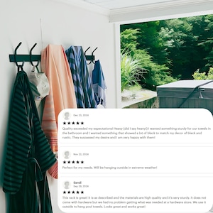 May include: Black metal towel rack with five hooks mounted on a white wall. Towels are hanging on the hooks. The rack is installed near a window with a view of a hot tub and green trees. Customer reviews are visible below the image.