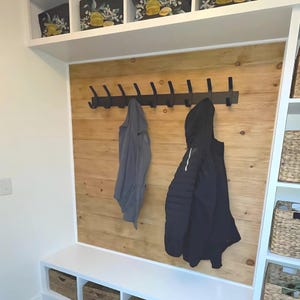 Mudroom built in with coat rack mounted on natural ship lap.