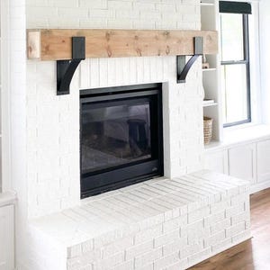 Close-up of handmade metal mantel bracket showing raw steel finish and concave support design
