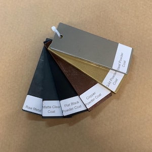 May include: A fan of metal powder coat color samples, including Raw Metal, Matte Clear Coat, Flat Black Powder Coat, Copper Powder Coat, Gold Powder Coat, and Steel Powder Coat. Each sample has a white label.