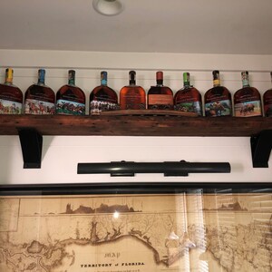 shelf support brackets supporting a liquor shelf. four inch wide with a four inch curved support bar