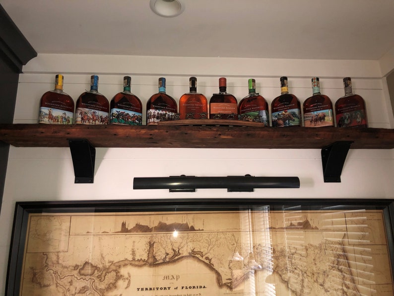 shelf support brackets supporting a liquor shelf. four inch wide with a four inch curved support bar