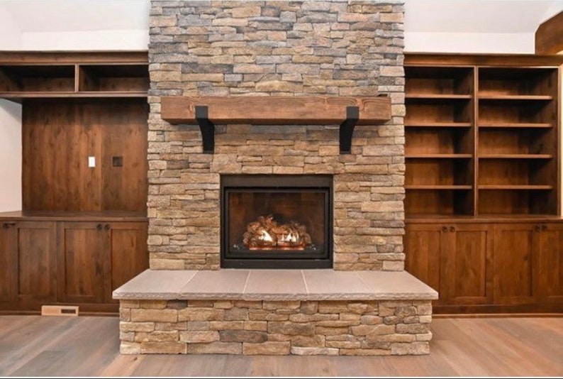 Metal Fireplace Mantel Brackets Mounted to Rustic Stone. Set of steel mantel brackets with powder coat finish in black, copper, and clear options