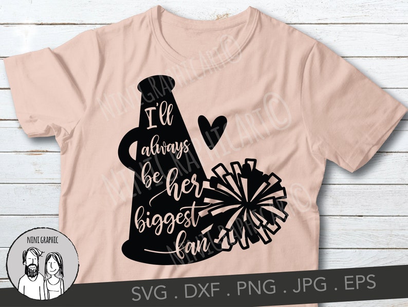 May include: A light pink t-shirt featuring a black cheerleader megaphone design with the words "I'll always be her biggest fan" and a heart. The design includes a pom-pom and is suitable for cheerleading fans.