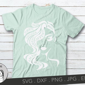 May include: A light green t-shirt featuring a white graphic of a woman's face with flowing hair. The hair design incorporates words like "Strong", "Wise", and "Beloved" in Spanish. The shirt also includes the text "NINI GRAPHIC" and file type information.