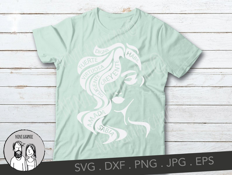 May include: A light green t-shirt featuring a white graphic of a woman's face with flowing hair. The hair design incorporates words like "Strong", "Wise", and "Beloved" in Spanish. The shirt also includes the text "NINI GRAPHIC" and file type information.