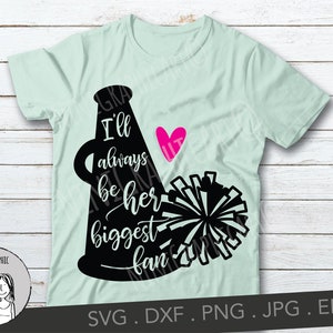May include: A light green t-shirt with a black cheerleader megaphone graphic and the words "I'll always be her biggest fan" in white script. A pink heart with the word "HIT" is also included. A black and white pom-pom is next to the megaphone.