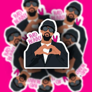 May include: A sticker featuring a stylized illustration of a man wearing sunglasses and a black hat, forming a heart shape with his hands. The text "BAD BUNNY" is above the man. A pink bunny is on his shoulder. The background is pink.